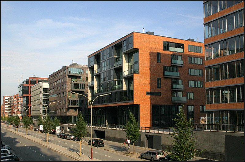 Neubauten am Sandtorkai der Speicherstadt. Gut erkennbar die gegenber der berflutungsgefhrdeten Straenebene erhhten Zugangsbereich zu den Gebuden. Auf der Rckseite der architektonisch interessanten Wohn- und Brohusern befindet sich der Sandtorhafen. 14.7.2007 (Matthias)