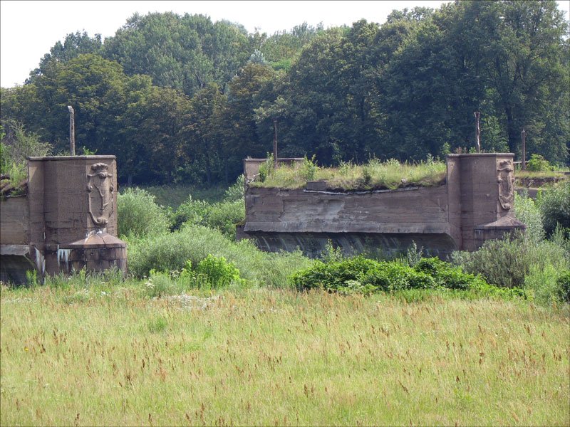 Stehengebliebene Pfeiler der groen Neiebrcke (1922 erbaut, 1945 zerstrt) in Forst/Lausitz. Der im Bild links zu sehende Pfeiler trgt das Wappen des Geschlechts derer von Bieberstein (gebogene Hirschstange), das Wappen am im Bild rechts zu sehenden Pfeiler ist das Wappen der Tuchmacher. Seit 1945 ist das rechte Ufer der Lausitzer Neie polnisches Territorium. - 21.07.2007
