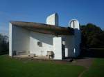 Wallfahrtskirche in Ronchamp / Frankreich,  hier ist die Ostseite zu sehen, sie bildet mit dem berhngenden Dach eine Freiluftkapelle mit Freialtar und Auenkanzel, die Nordseite mit