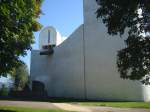 Wallfahrtskirche in Ronchamp / Frankreich,   die fensterlose Westseite mit skulpturartigem Wasserspeier, dahinter der Nordturm und einer Brunnenskulptur vor der Wand,  Sept.2010