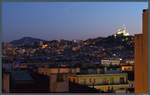 Abendlicher Ausblick einem Hotelzimmer ber die Dcher von Marseille zur Kirche Notre-Dame de la Garde.