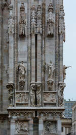 Kunstvoll gestaltete Figuren und Fresken an der Fassade des Mailnder Doms.