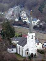 Im Vordergrund des Bildes sieht man die Kirche von Kautenbach, im Hintergrund erkennt man den Bahnhof.