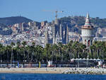 Blick vom Wasser auf den Strand von Barcelona, im Hintergrund deutlich zu erkennen der 45 Meter hohe Wasserturm  Torre d’aiges de la Catalana de Gas  und die  ewige Baustelle  Sagrada