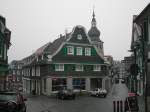 Ein groes, mit Schieferplatten verkleidetes Haus und die Kirche in Remscheid-Lennep am 12.03.2004.