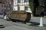 Otterberg in der Pfalz, der Sandsteinbrunnen auf dem Kirchplatz zeigt im  beidseitigen Relief historische Ereignisse der Stadtgeschichte, April 2011 