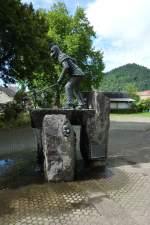 Kollnau, der Brunnen mit der Kollnauer Narrenfigur  Feuerteufel  wurde 1977 aufgestellt, Aug.2011
