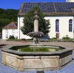 Herten, Stadtteil von Rheinfelden (Baden), der Dorfbrunnen auf dem Platz vor der Kirche St.Urban, Sept.2019