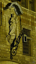 Die Jungfrau Maria mit Kind als Kunstwerk an einer Wand in der Antwerpener Innenstadt.