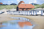 Wei�e Badeh�user am Strand von L�kken, mit der Rettungsstation im roten Backsteingeb�ude im Hintergrund.