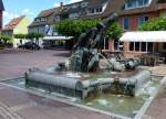 Neuenburg am Rhein, die Brunnenanlage  Monument  auf dem Rathausplatz, eine in Bronze gegossene Stadtchronik, Juni 2012