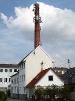 Wyhl am Kaiserstuhl, stillgelegter Schornstein mit Mehrfachnutzung, Sendemast und oben das Storchennest, Mai 2013