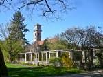 Nahe des Rosenparks am Rande des Frther Stadtparks kann man zwischen den Bumen hindurch den Turm der 1825 im Stil des Klassizismus erbauten Auferstehungskirche erkennen.