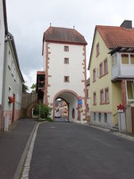 Neubrunn, Torturm der Ortsbefestigung, Durchfahrt mit Rundbogen und Spitzbogen, darber drei Geschosse und Halbwalmdach, Mitte 15.