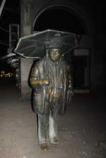 Mann mit Regenschirm  bei Nacht am 08.03.2011 in Hannover.