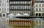 Fachwerkhaus in Hildesheim mit Spiegelbild im Rolandbrunnen.