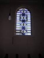 Auf diesem Foto ist ein Kirchenfenster von innen zu sehen.