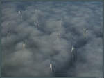 Windräder ragen aus dem Nebelmeer.