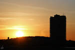 Sonnenuntergang zwischen altem Leuchtturm und dem 119 Meter hohem Maritim-Hochhaus in Travemnde.