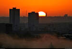 Sonniger Herbstmorgen (1/3):  Sonnenaufgang zwischen den  Punkthochhusern  von Halle-Neustadt und der Johanneskirche in der Altstadt von Halle (Saale), mit Tele-Zoom fotografiert vom Granauer