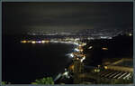 Am Abend des 23.02.2024 beleuchten die Lichter des Ortes Giardini-Naxos die Kstenlinie.