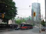 In den Strassenschluchten von Toronto: Die Tram hat eben das Rathaus passiert, im Hintergrund der  Glaspalast .