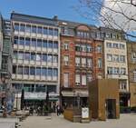 Unterschiedliche Fassaden an der Place Guillaume II mit dem Vordergrund den Lift zum Parkhaus unter dem Platz.