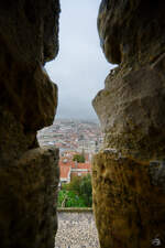 Blick durch eine der Schie- und Beobachtungsscharten der Festungsanlage Castelo de So Jorge auf das Zentrum der portugiesischen Hauptstadt Lissabon.