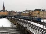 Zwischen den Stationen Gamla Stan und Slussen fhrt die Stockholmer U-Bahn oberirdisch; im Hintergrund links die Riddarholmskyrkan, die Grabkirche vieler schwedischer Knige - 15.03.2006  