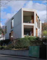 Moderne Architektur in der Umgebung von Basel -    Zwei Einfamilienhuser aus Sichtbeton in Riehen, die wie zwei Findlinge am Hang liegen.