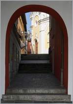 Ascona: Von der Seepromenade gleitet ein Blick durch Tor in ein schmales Gsschen.