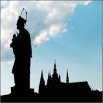 Die Statue des heiligen Johann von Nepomuk auf der Karlsbrcke vor dem Veitsdom im Hintergrund.