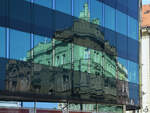 Ein historisches Gebude spiegelt sich in einer modernen Glasfassade.