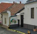 Strassenansicht mit einem stimmungsvollen Gemälde auf einem Hauswand in Pécs, Ungarn.