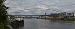 Die Fußgänger- und Fahrradbrücke über die Maas in Maastricht, links im Bild sieht man das Botelschiff was fest am Ufer verankert ist.