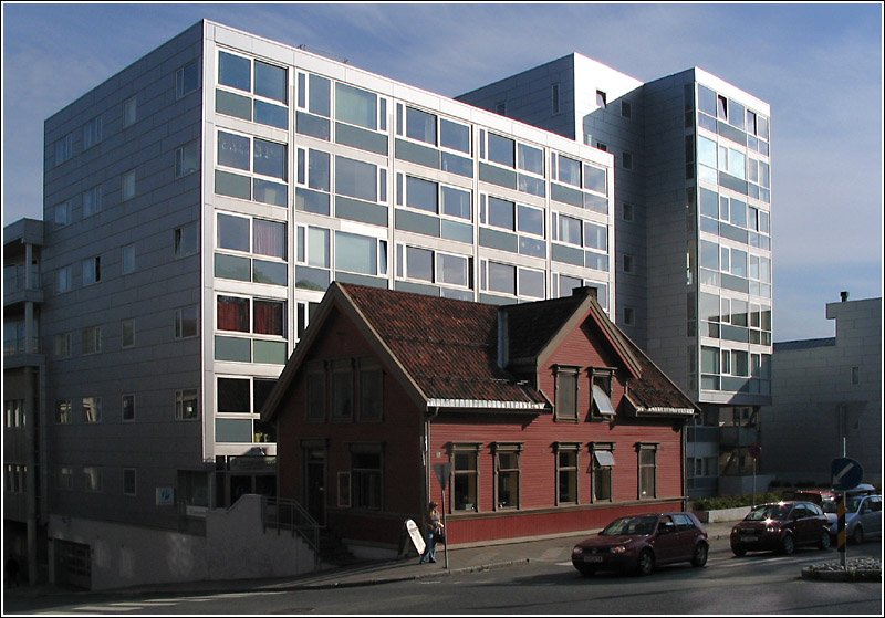 Tromser Kontraste: So schn die landschaftliche Lage von Troms auch ist, in der Innenstadt gibt es doch einige stdtebauliche Ausrutscher. Hier ein kleines typisch norwegisches Holzhaus, dahinter ein mastabssprengender Appartmentblock. Das kleine rote Haus beherbergt brigens eine Steinofenbckerei. 16.8.2006 (Jonas)