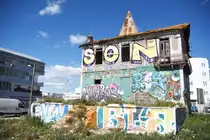 OLH�O, 06.03.2022, die R�ckseite eines mit Graffiti verzierten, unbewohnten Hauses an der N-125; das sieht in jedem Fall besser aus, als wenn das Haus unverziert vor sich hingammeln w�rde; ansonsten ist es in Portugal genauso schlimm wie in Deutschland: es gibt nichts, wo sich nicht mindestens ein - gef�hlt - extra dazu berufener  K�nstler  zum Beschmieren findet