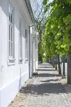 Wei� gestrichenes Haus und B�rgersteig in der Slotsgade (deutsch Schlo�stra�e) in Fredensborg auf Seeland. Aufnahme: 24. Juni 2023.