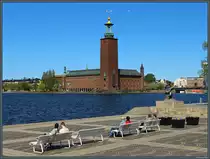 Das 1911 - 1923 erbaute Rathaus Stockholms liegt am Ufer des M�larsee im Zentrum der schwedischen Hauptstadt. Gegen�ber dem Rathaus liegt die Insel Riddarholmen. Dort erinnert eine Statur an den schwedischen S�nger und K�nstler Evert Taube. (Stockholm, 19.05.2023)