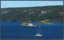 Im Olsofjord liegt die Inselgruppe Steilene. Vorn links liegt die Insel Fyrsteila mit ihrem Leuchtturm. Dahinter liegt die als Vogelschutzgebiet genutzte Insel Knerten. Der groe Fischltank rechts erinnert an die industrielle Nutzung auf der Insel Storsteilene. (28.05.2023)