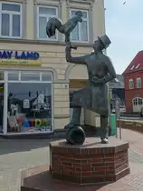 Heide/Holstein am 10.4.2023: Am Ende der S�derstra�e steht die gusseiserne Figur des Hahnbeermanns, von Siegfried Assmann, das an die seit 1841 bestehende Tradition des S�dereggen-Hahnbeer mit Bo�elkugel, Hahn und Holztonne, Bis heute ist das Hahnbeer (plattdeutsch f�r Hahnenfest) ein H�hepunkt im Heider Kalender.