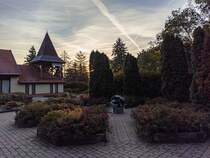 Haupteingang des Puchner Schlohotel. Links das Gebude des Empfangs, davor schne Pflanzen und ien Erdkugel (temporr). Foto: Oktober, 2023.