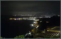 Am Abend des 23.02.2024 beleuchten die Lichter des Ortes Giardini-Naxos die K�stenlinie. Der Ort liegt unterhalb von Taormina. 
