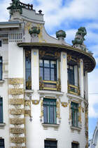 Das Jugendstilhaus in der Linken Wienzeile 38 in Wien ist bekannt fr seine spektakulre Ecklsung, die in Form eines Viertelkreises ausgefhrt ist. Die auf dem Dach thronende Skulptur der Ruferinnen stammt vom sterreichischen Bildhauer Othmar Schimkowitz, der einige Jahre spter fr Wagners Kirche am Wiener Steinhof die Engelsfiguren schuf. Aufnahme: 18. Mai 2024.