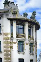 Das Jugendstilhaus in der Linken Wienzeile 38 in Wien ist bekannt f�r seine spektakul�re Eckl�sung, die in Form eines Viertelkreises ausgef�hrt ist. Die auf dem Dach thronende Skulptur der Ruferinnen stammt vom �sterreichischen Bildhauer Othmar Schimkowitz, der einige Jahre sp�ter f�r Wagners Kirche am Wiener Steinhof die Engelsfiguren schuf. Aufnahme: 18. Mai 2024.