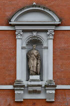 An der Seitenfassade des 1894 erbauten Stadttheater Flensburg befindet sich eine Figur der Flensburgia, welche mit der Stadtmauerkrone und dem Flensburgwappen auf dem Schild die Stadt verkrpern soll. (Flensburg, Juni 2024)