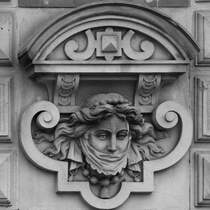 Diese verschleierte Dame befindet sich an der Fassade der Alten Post, einem ehemaligen Postgebude und heutigem Hotel aus dem 19. Jahrhundert. (Flensburg, Juni 2024)