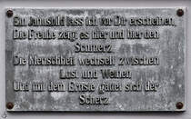 Eine Tafel an der Fassade des im Jahr 1894 erbauten Stadttheater in Flensburg. (Juni 2024)