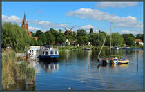 Blick vom Festland hinber zur Havelinsel, die die Altstadt von Werder beherbergt. Gut zu erkennen sind die Heilig-Geist-Kirche und die Bockwindmhle. Im Vordergrund ld der Schiffsanleger zu Rundfahren ber die Havel ein. (11.05.2024)