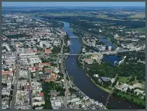 Blick auf die Stromelbe im Stadtzentrum von Magdeburg. Links verl�uft der Breite Weg, an dem in den letzten Jahren unter anderem das Domviertel und mehrere B�rohochh�user neu entstanden sind. Rechts der Elbe ist im Stadtparkt die nach langem Leerstand sanierte Hyparschale zu sehen, die 1969 errichtet wurde und nun als Kongresshalle dient. Oberhalb des Winterhafens ist die im M�rz 2024 er�ffnete Kaiser-Otto-Br�cke zu sehen. (Magdeburg, 09.06.2024)